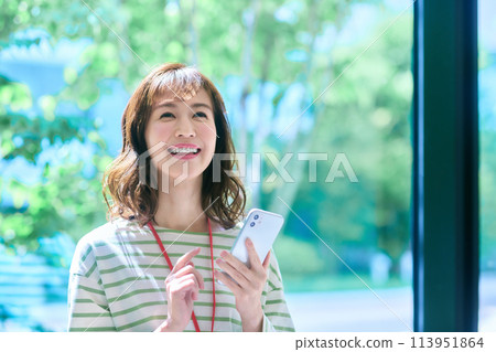 A female engineer in plain clothes operating a smartphone in the office Photo cooperation: LINK FOREST A female engineer in plain clothes operating a smartphone in the office Photo cooperation: LINK FOREST 113951864