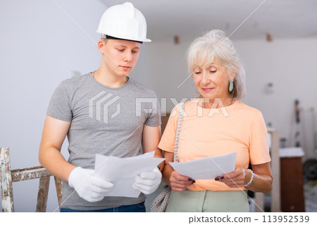 Teenager helping senior woman with home improvement works Teenager helping senior woman with home improvement works 113952539
