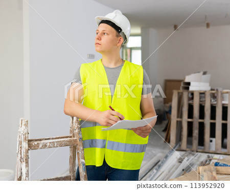 Teenager boy inspecting building site inside apartment Teenager boy inspecting building site inside apartment 113952920