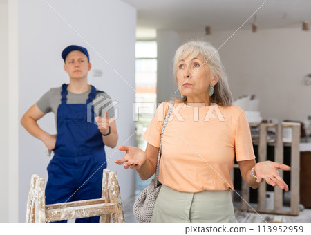Elderly woman is unhappy with the renovation of the room, which was carried out by young guy 113952959