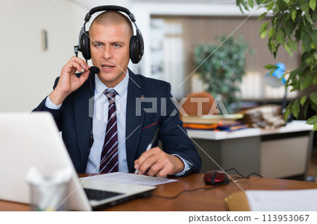 Man in earphones working at office 113953067