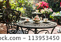 A charming English tea garden with wrought-iron tables and floral teacups 113953450