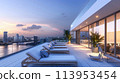 A chic rooftop terrace with lounge chairs and city skyline views 113953454