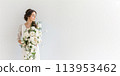 bride holding a cascading bouquet of white roses and peonies against a clean white background. 113953462
