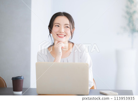 Cute young Japanese (Asian) woman with hand on chin thinking while using a computer Cute young Japanese (Asian) woman with hand on chin thinking while using a computer 113953935