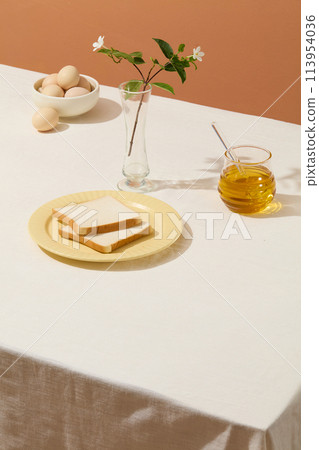 Layout for cooking photo with cooking ingredients featured on empty white table including sandwiches, honey and egg. Copy space, top view 113954036