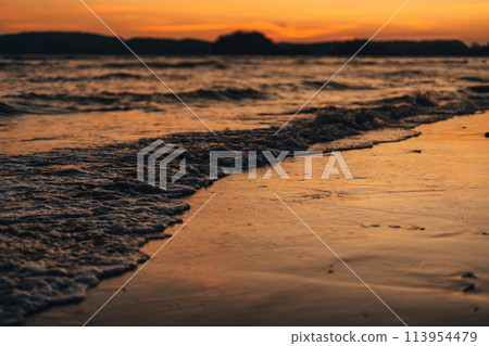 Beach and sea waves in the evening before sunset 113954479