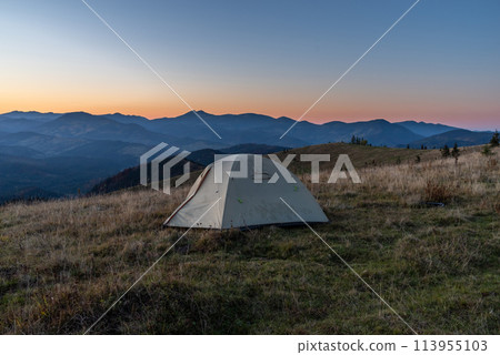 Tourist tent in the mountains. Sunrise in the mountains. Tourist camp and sunrise. Outdoors. 113955103