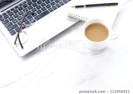 將膝上型電腦和筆記本放在桌子上,一邊喝咖啡一邊做案頭工作的圖片 將膝上型電腦和筆記本放在桌子上,一邊喝咖啡一邊做案頭工作的圖片 113956951