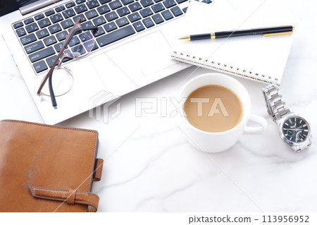 將膝上型電腦和筆記本放在桌子上,一邊喝咖啡一邊做案頭工作的圖片 將膝上型電腦和筆記本放在桌子上,一邊喝咖啡一邊做案頭工作的圖片 113956952