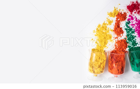 Colorful holi powder in a plastic containers on white background with copy space. 113959016