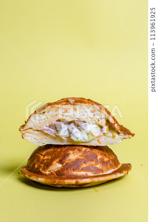 Half of burger with no top bread isolated on pastel yellow background 113961925
