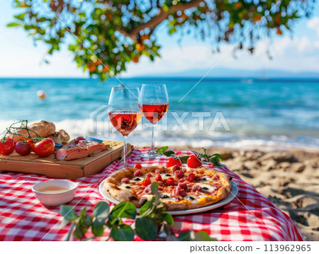 Seaside picnic with red wine in glasses, pepperoni pizza, and fresh grapes on checkered blanket. Romantic outdoor dining concept with a sea view and natural setting. Ai generation 113962965