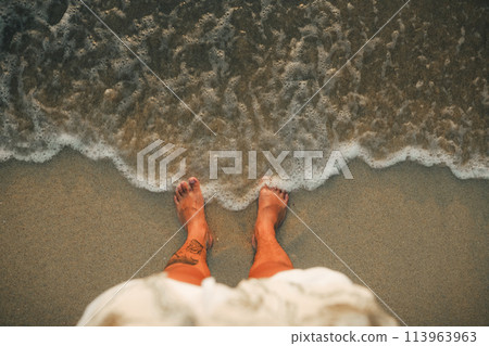 Feet with evening sea waves on the island Feet with evening sea waves on the island 113963963