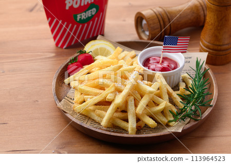 French fries on a wooden plate 113964523