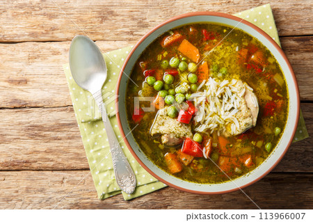 Aguadito de Pollo is a Peruvian cuisine, combining ingredients such as chicken, rice, vegetables and coriander in a tasty broth closeup on the bowl. Horizontal top view Aguadito de Pollo is a Peruvian cuisine, combining ingredients such as chicken, rice, vegetables and coriander in a tasty broth closeup on the bowl. Horizontal top view 113966007