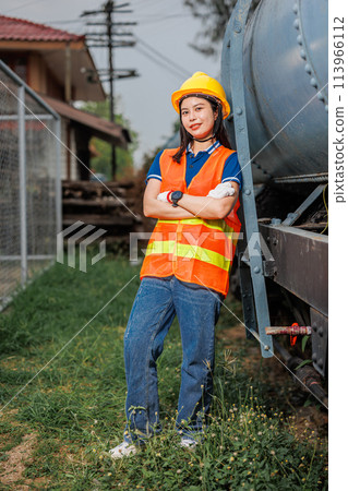 portrait train locomotive engineer women worker. Happy Asian young teen smiling work at train station train track locomotive service maintenance. portrait train locomotive engineer women worker. Happy Asian young teen smiling work at train station train track locomotive service maintenance. 113966112