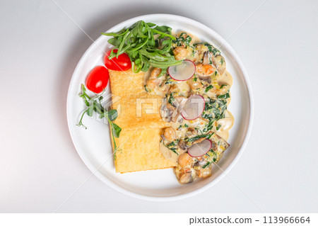 Top view Savory crepe with creamy mushroom sauce and fresh greens on a white plate Top view Savory crepe with creamy mushroom sauce and fresh greens on a white plate 113966664