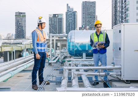 engineer teamwork technician workers service hotel boiler tank hot water supply pipe system. team working safety checking maintenance pipeline heating water delivery line at roof top outdoor. 113967020