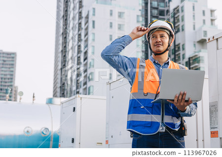 engineer male technician worker working service commercial building heat pump hot water supply systems. man safety checking maintenance heating water machine at roof top outdoor. 113967026