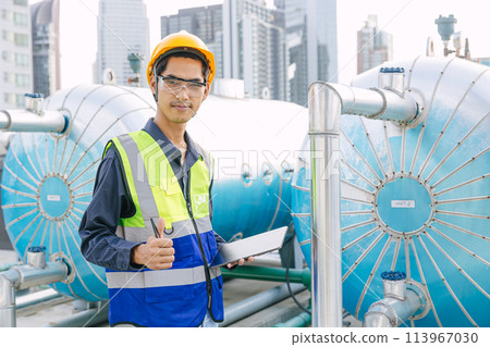 portrait gas pipe engineer worker on site service working maintenance hot water tank at roof top outdoor commercial building happy smiling. portrait gas pipe engineer worker on site service working maintenance hot water tank at roof top outdoor commercial building happy smiling. 113967030