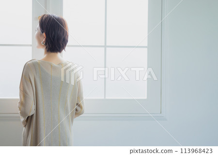 Woman looking out the window 113968423