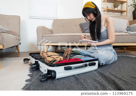 Woman and suitcase for travel summertime vacation packing clothing. relax and getaway preparation Woman and suitcase for travel summertime vacation packing clothing. relax and getaway preparation 113969175