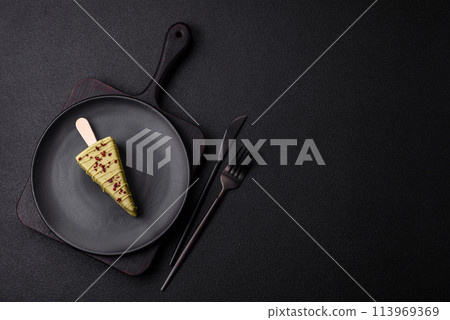 Delicious sweet cheesecake with fruits covered with icing with a wooden stick Delicious sweet cheesecake with fruits covered with icing with a wooden stick 113969369