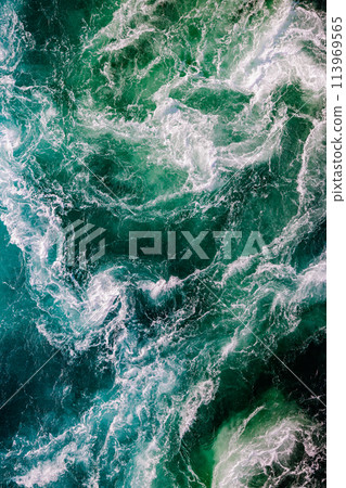 Blue waves of water of the river and the sea meet each other during high tide and low tide. 113969565