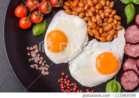 English breakfast with fried eggs, bacon, beans, tomatoes, spices and herbs English breakfast with fried eggs, bacon, beans, tomatoes, spices and herbs 113969599