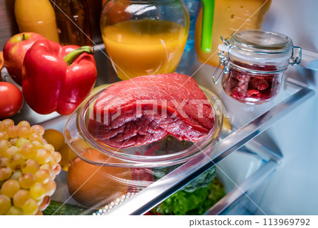 Fresh raw meat on a shelf open refrigerator Fresh raw meat on a shelf open refrigerator 113969792