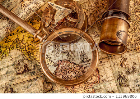 Vintage style travel and adventure. Vintage old compass and other vintage items on the table. Vintage style travel and adventure. Vintage old compass and other vintage items on the table. 113969806