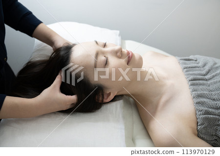A woman receiving head spa treatment 113970129