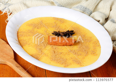Curau, cream of corn sweet and dessert typical of the Brazilian cuisine, placed in ceramic bowl on wooden table. 113970377