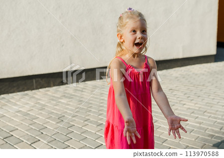 Child girl with hearing aids and cochlear implants having fun outdoor speak and playing. Inclusion and disability. Copy space and empty place for advertising. 113970588
