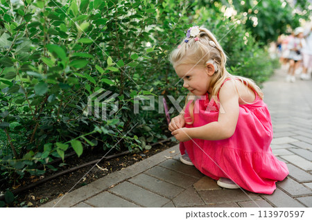 Child girl with hearing aids and cochlear implants having fun outdoor speak and playing. Inclusion and disability. 113970597