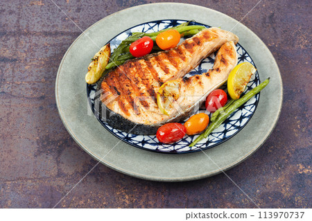 Grilled trout steak on a plate. Grilled trout steak on a plate. 113970737