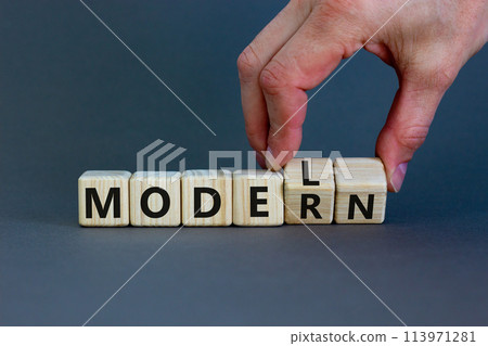 Modern model symbol. Businessman turns wooden cubes and changes the word 'model' to 'modern'. Beautiful grey table, grey background, copy space. Business and modern model concept. Modern model symbol. Businessman turns wooden cubes and changes the word 'model' to 'modern'. Beautiful grey table, grey background, copy space. Business and modern model concept. 113971281