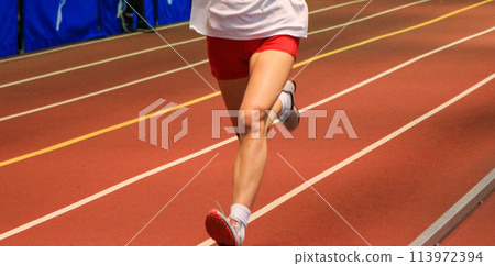 Legs of a runner on an indoor track 113972394