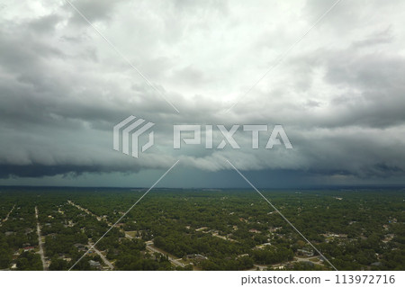Landscape of dark ominous clouds forming on stormy sky before heavy thunderstorm over rural town area 113972716