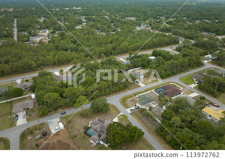 Aerial landscape view of suburban private houses between green palm trees in Florida rural area Aerial landscape view of suburban private houses between green palm trees in Florida rural area 113972762