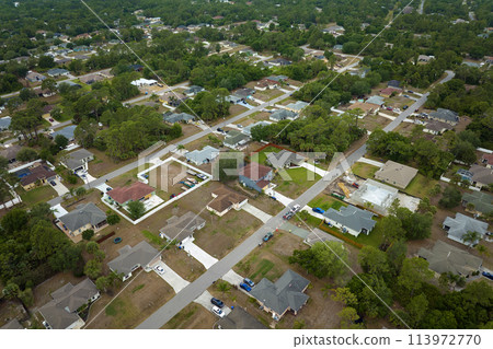 Aerial landscape view of suburban private houses between green palm trees in Florida rural area Aerial landscape view of suburban private houses between green palm trees in Florida rural area 113972770