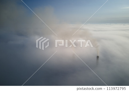 Coal power plant high pipes emitting black poisonous smoke moving upwards over white fog polluting air. Production of electrical energy with fossil fuel concept Coal power plant high pipes emitting black poisonous smoke moving upwards over white fog polluting air. Production of electrical energy with fossil fuel concept 113972795
