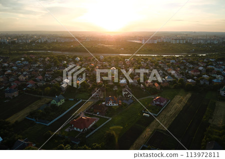 Aerial view of residential houses in suburban rural area at sunset Aerial view of residential houses in suburban rural area at sunset 113972811