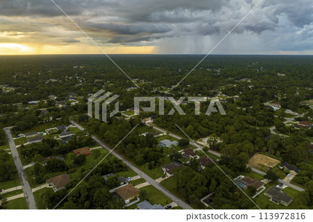 Landscape of dark ominous clouds forming on stormy sky during heavy thunderstorm over rural town area 113972816