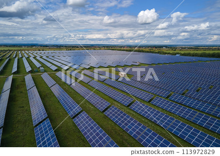 Aerial view of big sustainable electric power plant with many rows of solar photovoltaic panels for producing clean electrical energy. Renewable electricity with zero emission concept Aerial view of big sustainable electric power plant with many rows of solar photovoltaic panels for producing clean electrical energy. Renewable electricity with zero emission concept 113972829