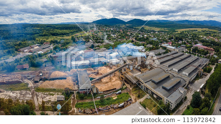 Aerial view of wood processing plant with smokestack from production process polluting environment at factory manufacturing yard 113972842