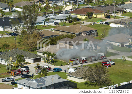 Burning residential house on fire with smoke and flames after short circuit spark ignited wooden roof damaged by hurricane Ian. Home disaster in Florida rural area Burning residential house on fire with smoke and flames after short circuit spark ignited wooden roof damaged by hurricane Ian. Home disaster in Florida rural area 113972852