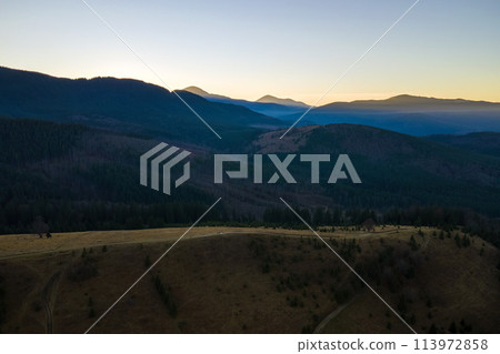Beautiful mountain panoramic landscape with hazy peaks and foggy valley at sunset Beautiful mountain panoramic landscape with hazy peaks and foggy valley at sunset 113972858