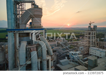 Aerial view of cement factory with high concrete plant structure and tower crane at industrial production site. Manufacture and global industry concept Aerial view of cement factory with high concrete plant structure and tower crane at industrial production site. Manufacture and global industry concept 113972875